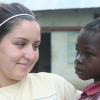 A volunteer holding a young child at a partner program